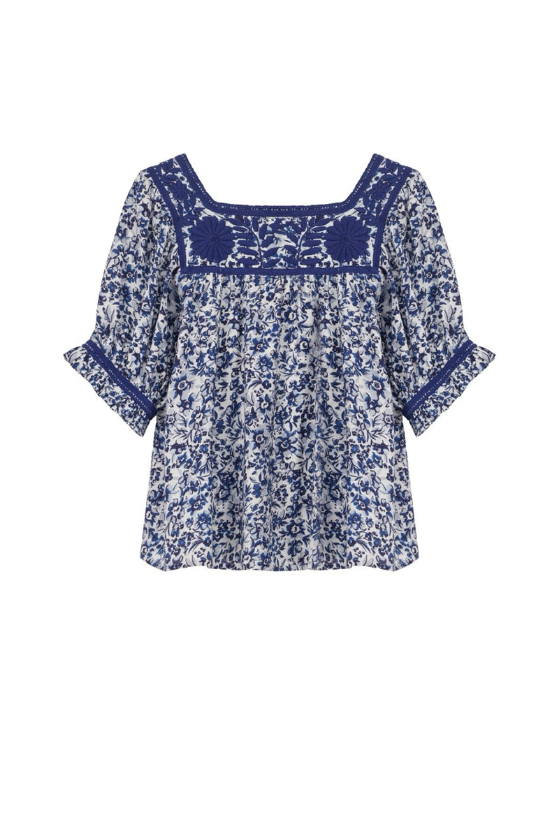 Blue floral blouse with lace details on a white background