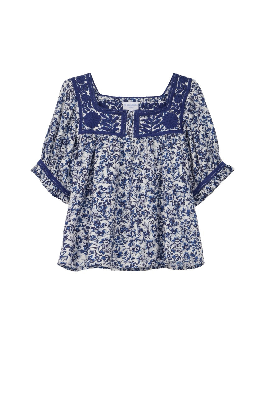 Blue floral blouse with lace details on a white background