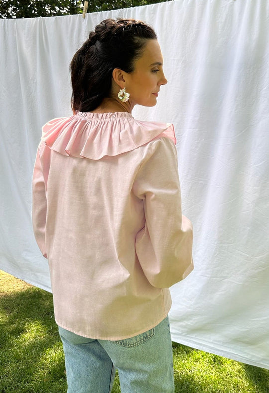Regina pink ruffled long sleeved blouse with jeans